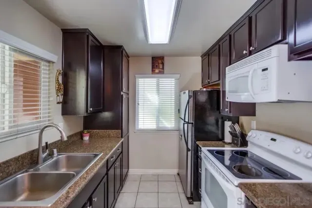 a kitchen that has a sink cabinets counter space and appliances