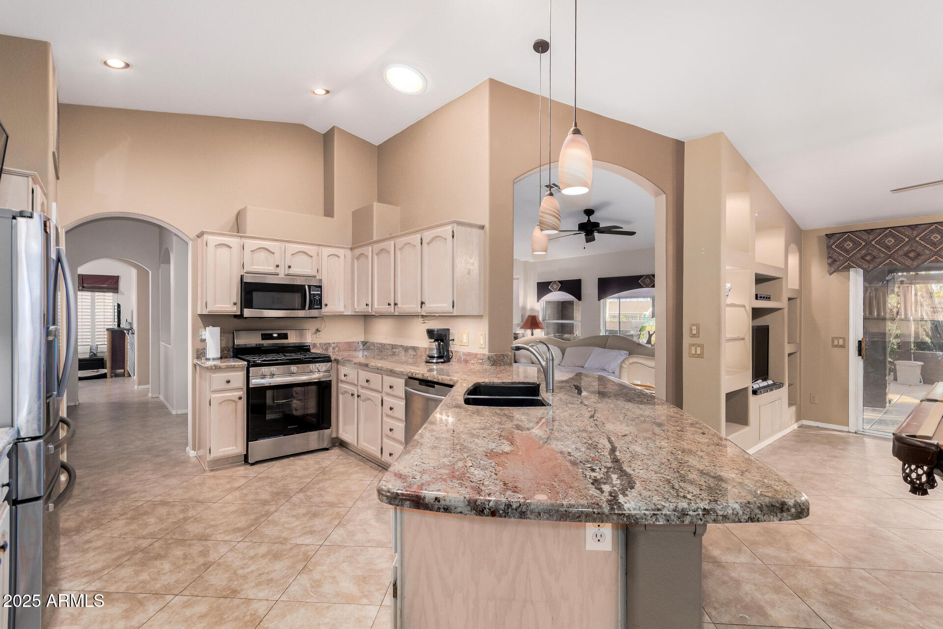 15531 Piccadilly Road Goodyear, AZ 85395 - Photo 24 of 54 a large kitchen with stainless steel appliances granite countertop a stove oven and a sink