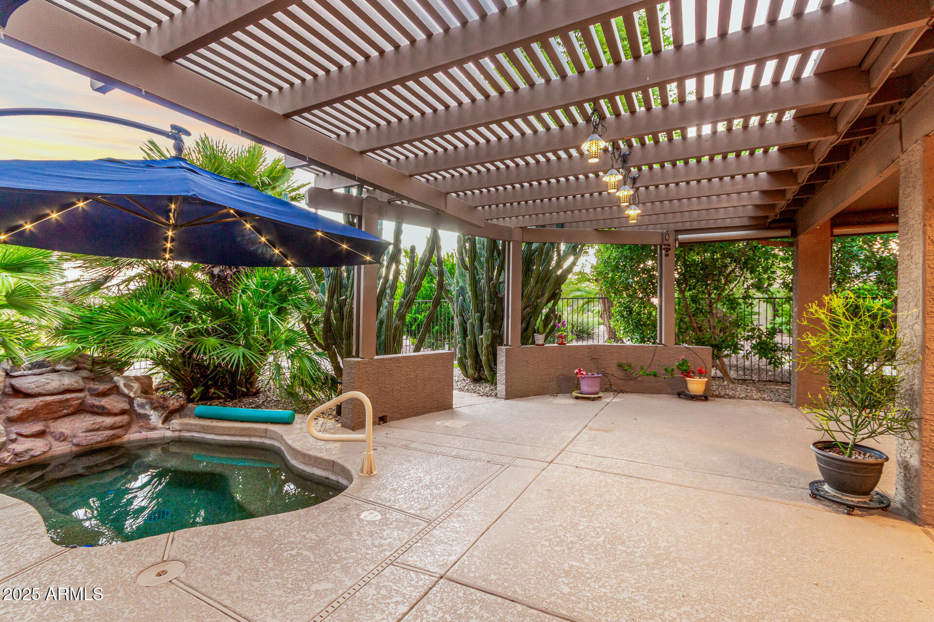 15531 Piccadilly Road Goodyear, AZ 85395 - Photo 41 of 54 a view of a patio with table and chairs potted plants with wooden floor and fence