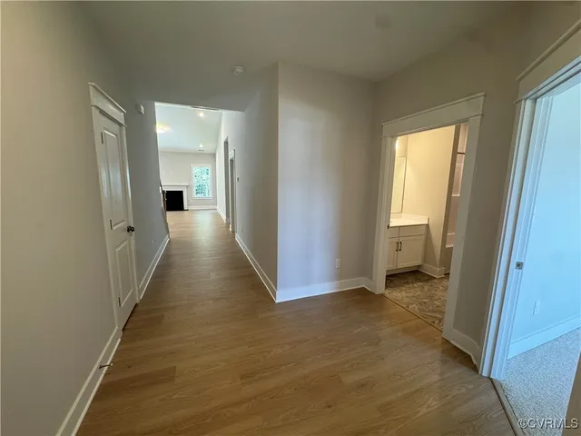 a view of a hallway with wooden floor and closet