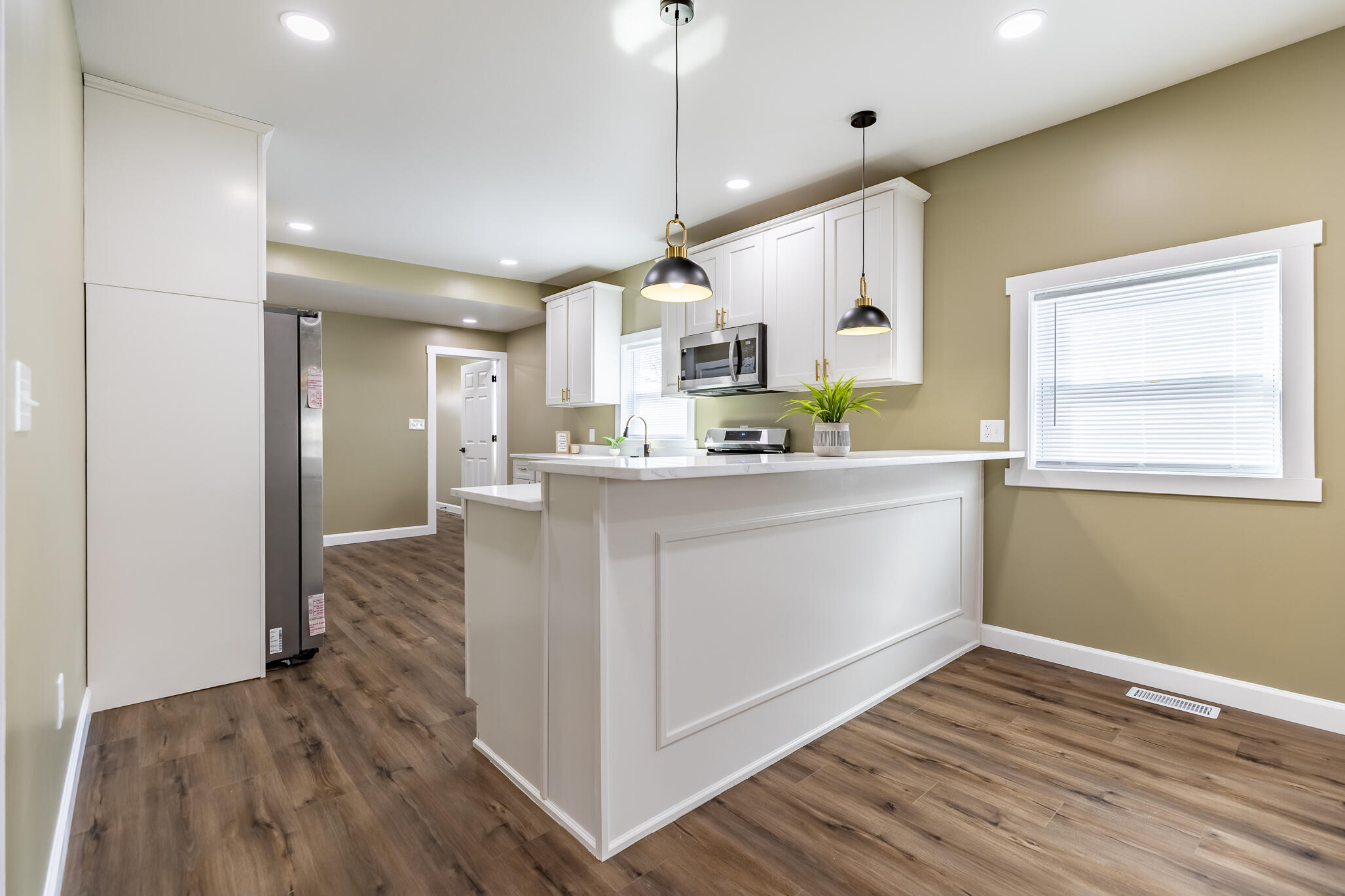 1047 Arizona Street Gary, IN 46403 - Photo 9 of 35 a kitchen with kitchen island white cabinets and wooden floor