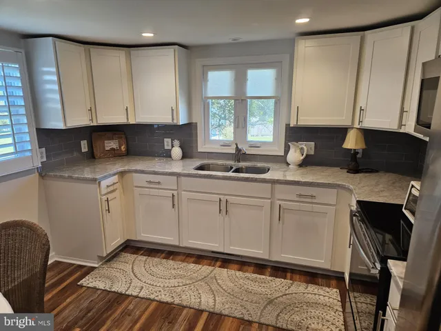 a kitchen with a sink window and cabinets