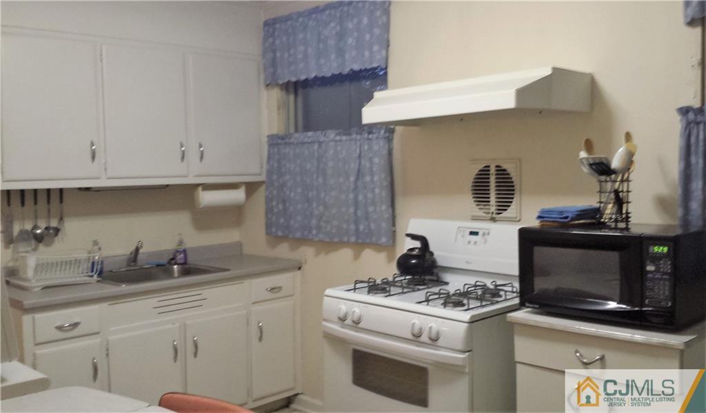 8 Longfield Road New Brunswick, NJ 08901 - Photo 5 of 8 a kitchen with stainless steel appliances a stove a sink and a microwave