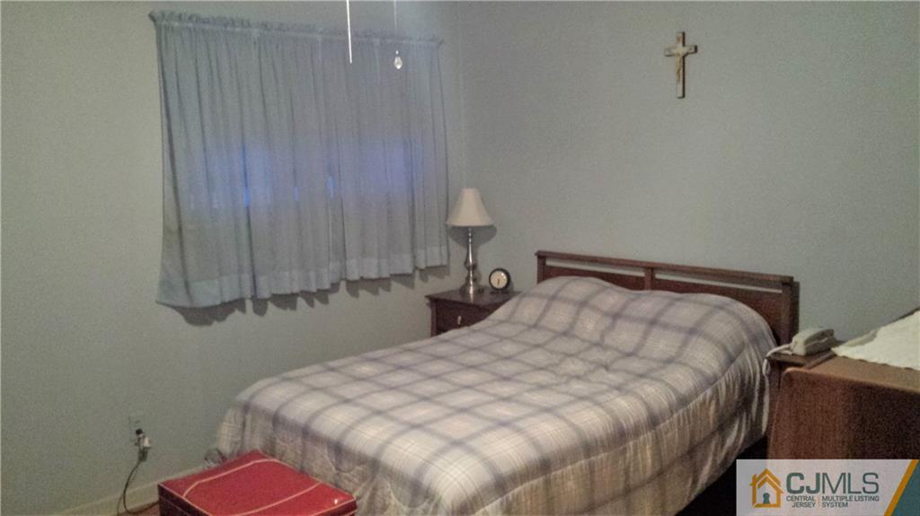 8 Longfield Road New Brunswick, NJ 08901 - Photo 7 of 8 a bedroom with a bed and a lamp on the dresser