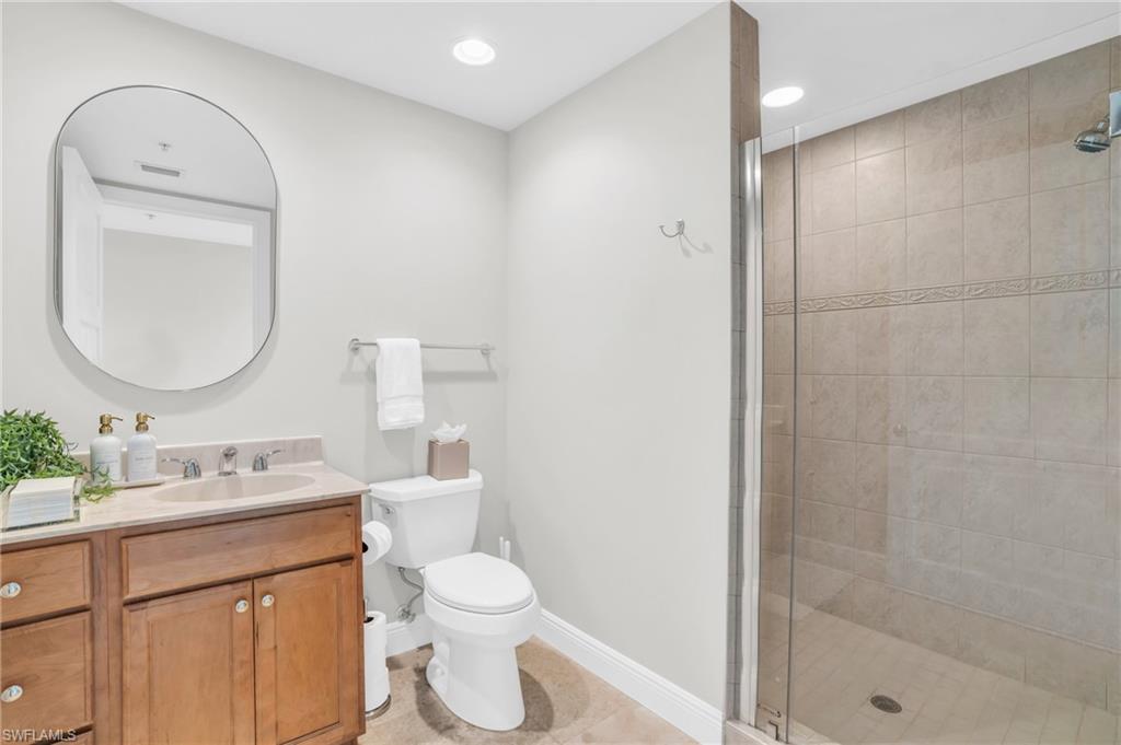 265 Indies Way, Unit 1404 Naples, FL 34110 - Photo 20 of 42 Bathroom with vanity, a shower with door, tile patterned flooring, and toilet