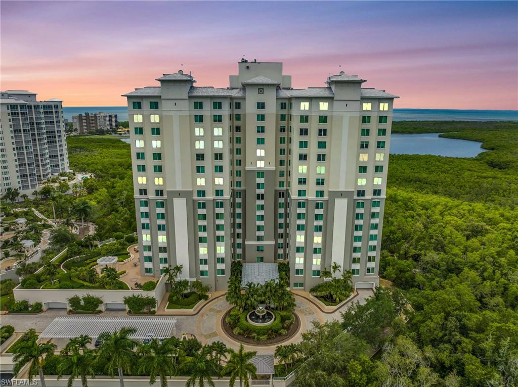 265 Indies Way, Unit 1404 Naples, FL 34110 - Photo 4 of 42 Outdoor building at dusk featuring a water view