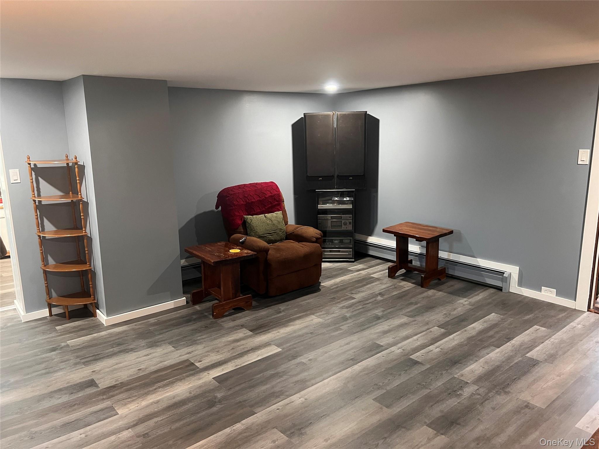 279 Cold Spring Road Monticello, NY 12701 - Photo 9 of 32 Living area with wood finished floors and a baseboard radiator