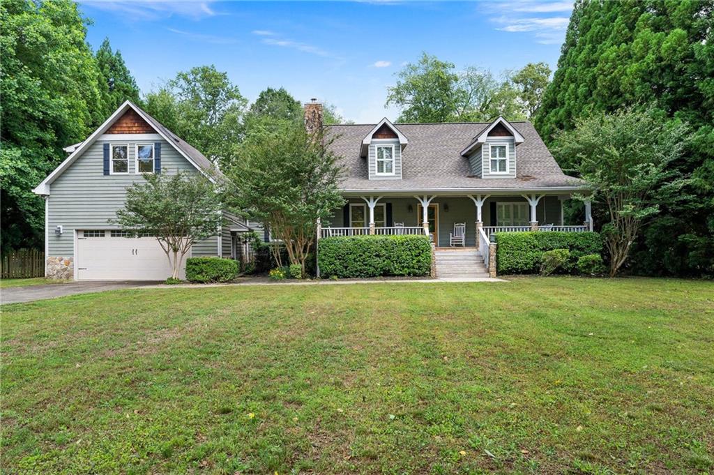 a front view of a house with a yard and trees