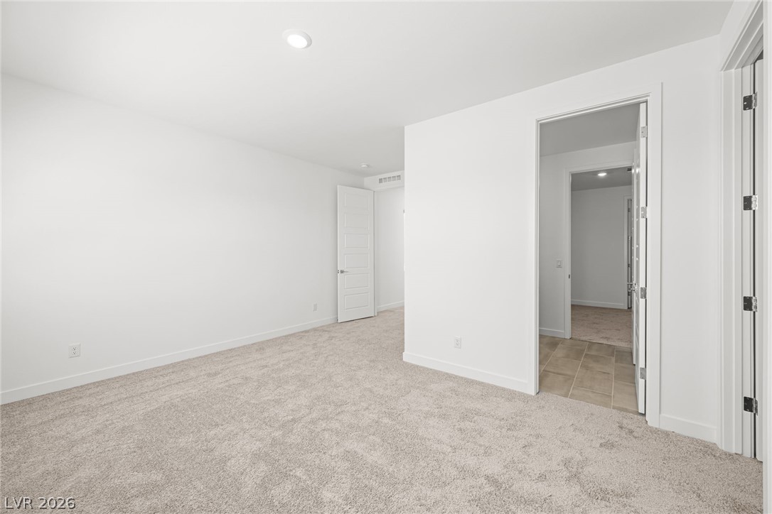 9983 Decano Ridge Street Las Vegas, NV 89141 - Photo 31 of 39 A spacious, neutral-toned room offers comfort and versatility.