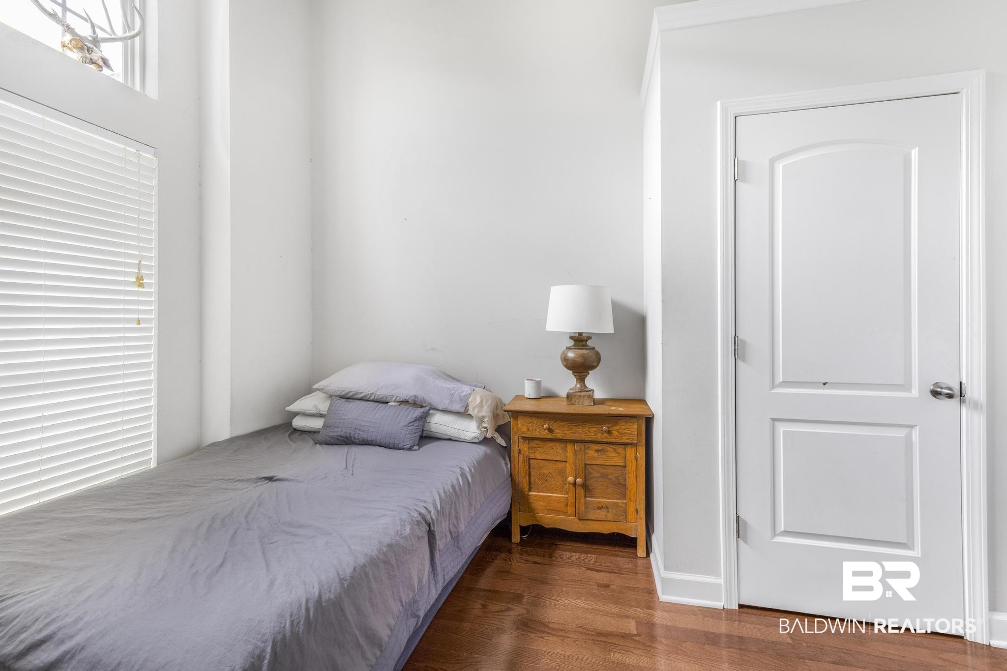 35814 Delvan Lane Bay Minette, AL 36507 - Photo 26 of 53 Interior space featuring wood-finish flooring, white walls, and a white interior door with paneling