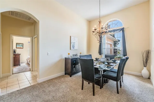 a view of a dining room with furniture and a chandelier