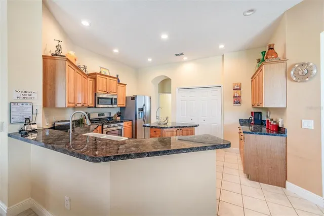a large kitchen with granite countertop a large counter top space appliances and cabinets