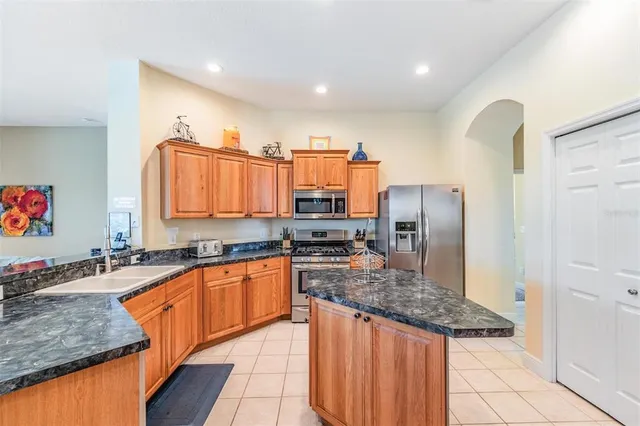 a kitchen with stainless steel appliances granite countertop a sink refrigerator and cabinets