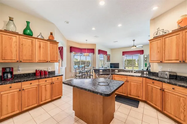 a kitchen with granite countertop a sink stove top oven and cabinets