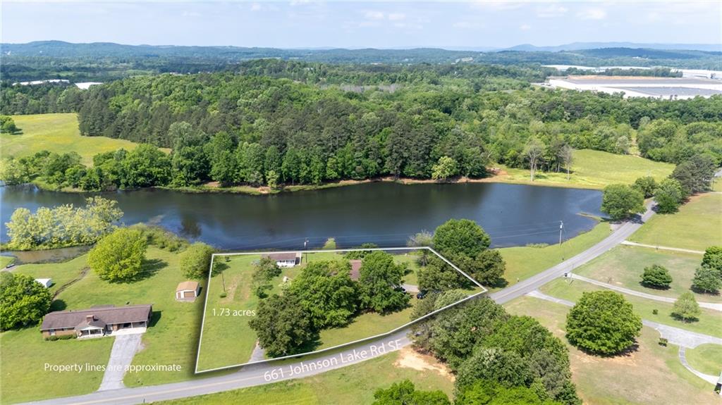 an aerial view of a residential houses with outdoor space and a lake view