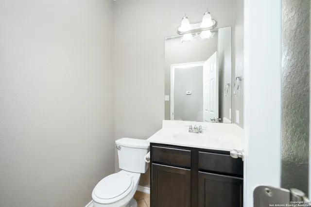 a bathroom with a sink vanity mirror and toilet