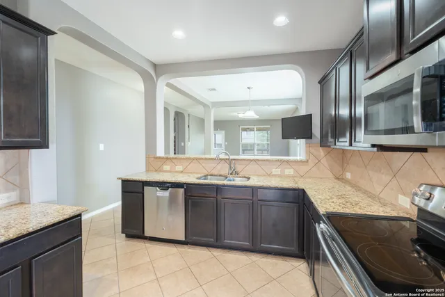 a large kitchen with a sink and stainless steel appliances