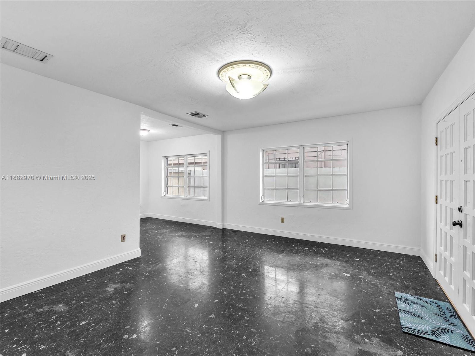 3680 Northwest 16th Street Miami, FL 33125 - Photo 11 of 45 wooden floor in an empty room with a window