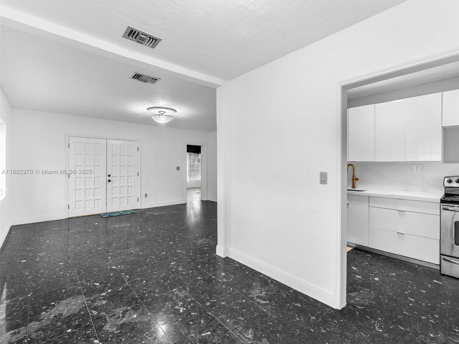 3680 Northwest 16th Street Miami, FL 33125 - Photo 12 of 45 a view of a kitchen with white cabinets and wooden floor