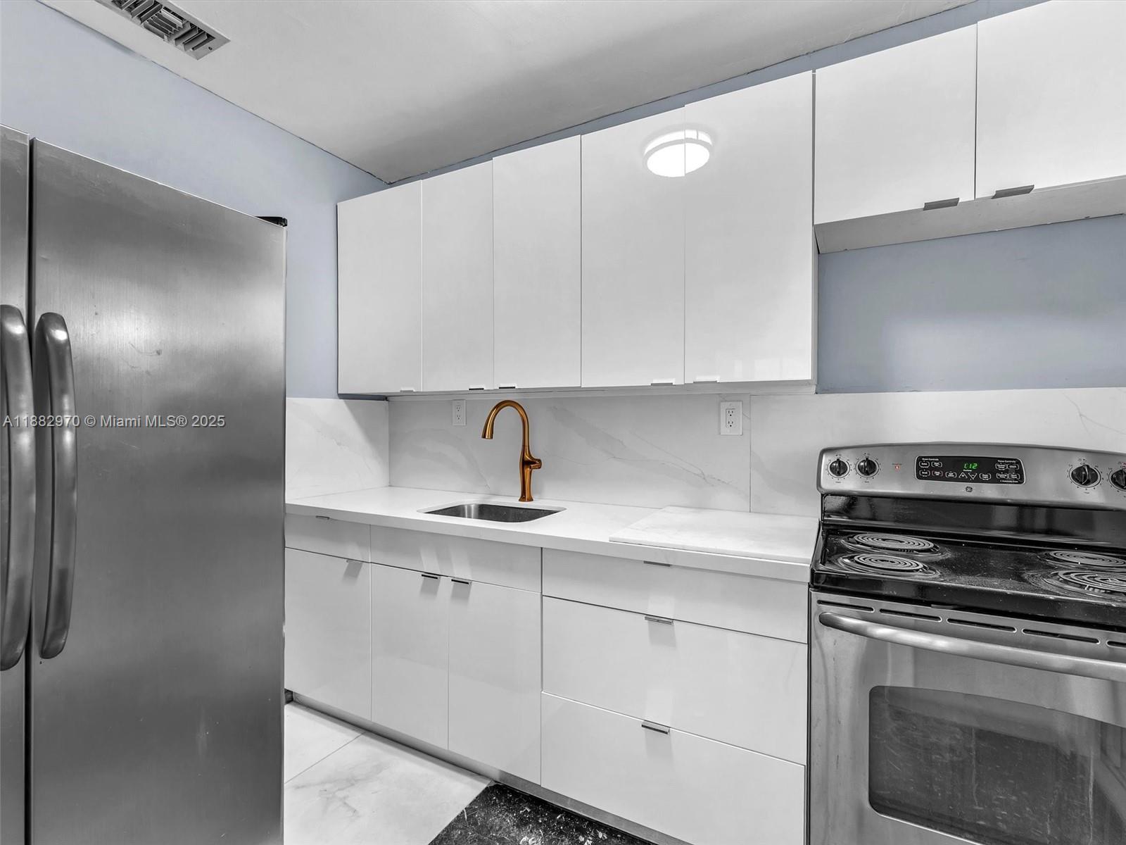 3680 Northwest 16th Street Miami, FL 33125 - Photo 13 of 45 a kitchen with a stove and a refrigerator