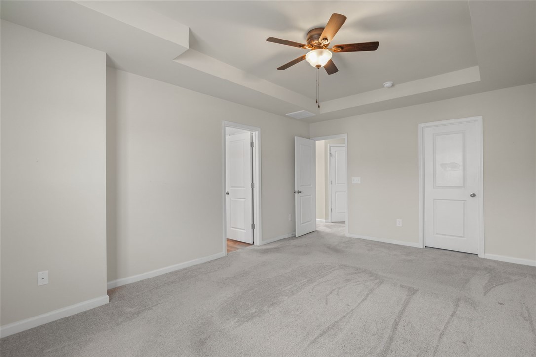 432 Bee Cv Way Pendleton, SC 29670 - Photo 19 of 39 This primary bedroom offers ample space with carpet flooring and elegant tray ceilings.