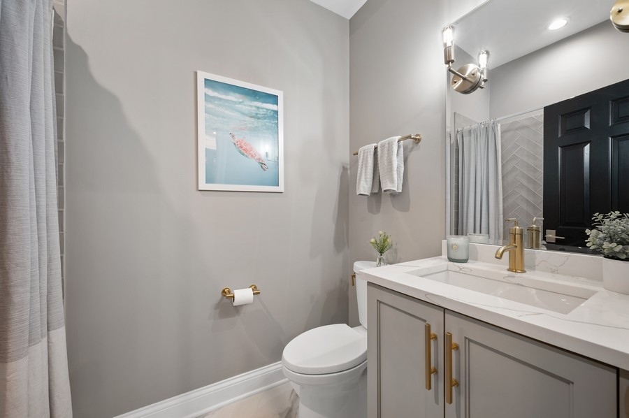 2919 North Burling Street, Unit D Chicago, IL 60657 - Photo 11 of 14 a bathroom with a granite countertop sink toilet and mirror