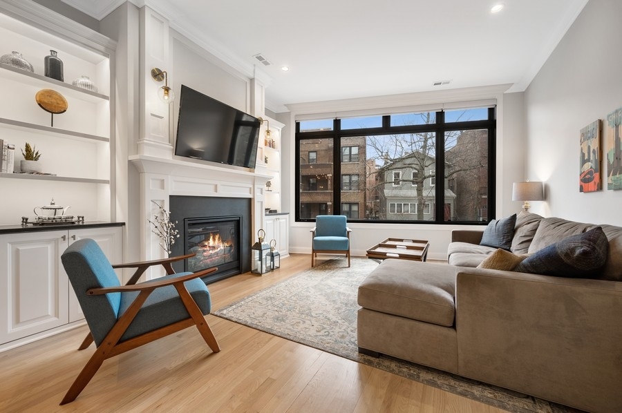 2919 North Burling Street, Unit D Chicago, IL 60657 - Photo 2 of 14 a living room with furniture a flat screen tv and a fireplace