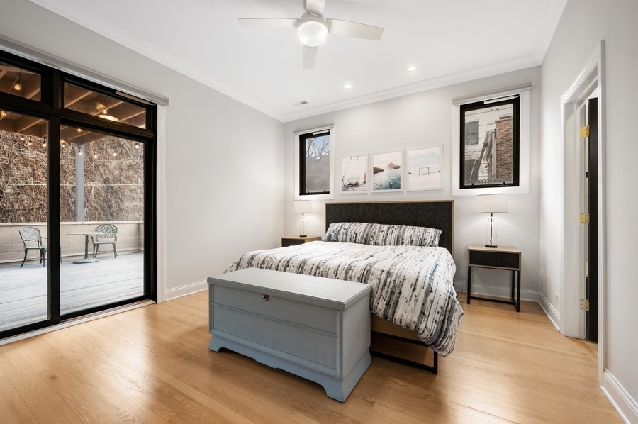 2919 North Burling Street, Unit D Chicago, IL 60657 - Photo 6 of 14 a spacious bedroom with a bed painting on wall and a large window