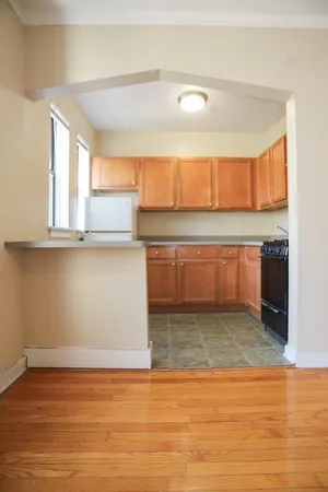 a view of a kitchen with kitchen island a sink wooden floor and a window