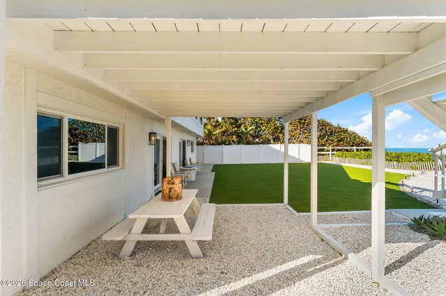 a view of a house with a yard and potted plants