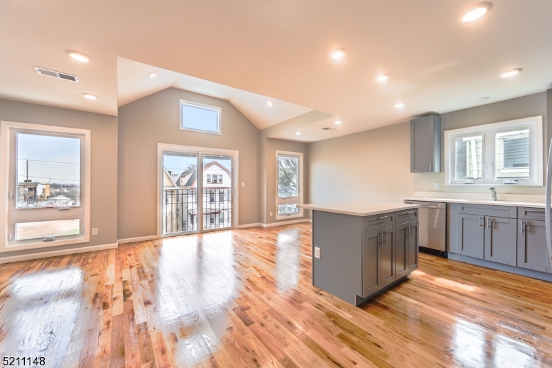 255 Chadwick Avenue, Unit 2 Newark, NJ 07108 - Photo 6 of 23 a living room with kitchen island granite countertop wooden floor and a sink
