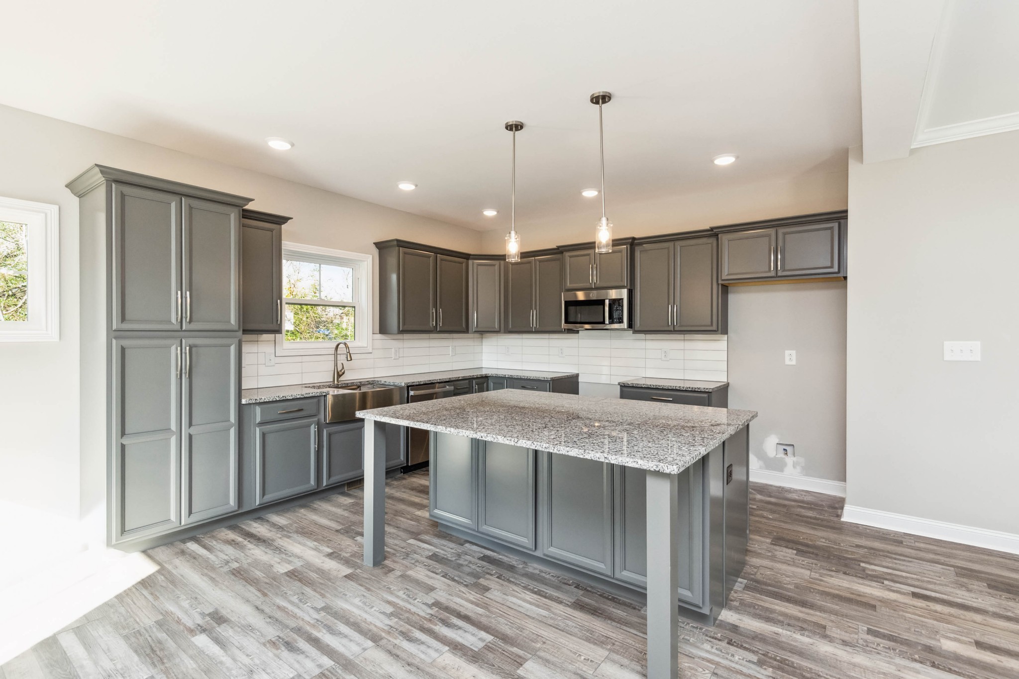 584 Lafayette Road Clarksville, TN 37042 - Photo 10 of 36 a kitchen with stainless steel appliances granite countertop a sink a stove a refrigerator and island with wooden floor