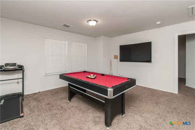 a room with pool table and flat screen tv