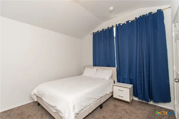 a large bed sitting in a bedroom next to a wooden door