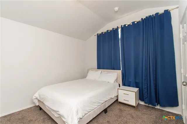 a large bed sitting in a bedroom next to a wooden door