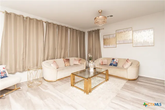 a living room with furniture and a chandelier