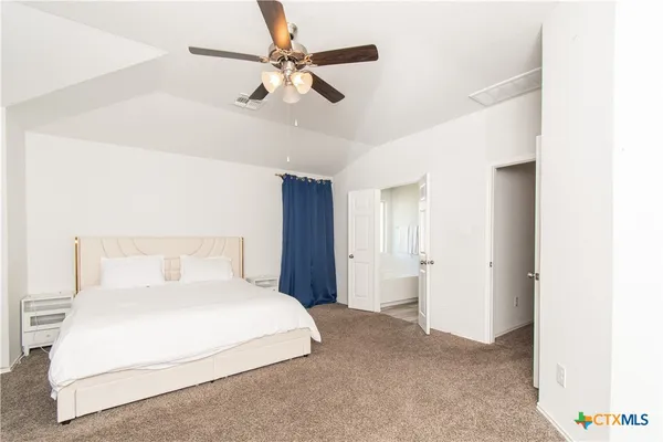 a bedroom with a large bed and a chandelier