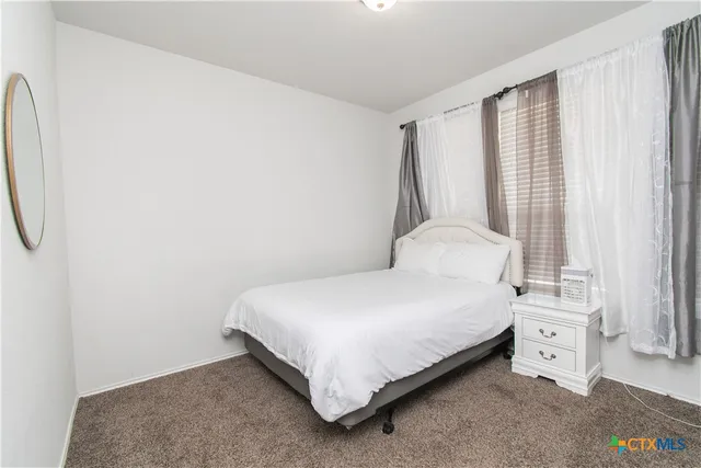 a large bed sitting in a bedroom next to a window
