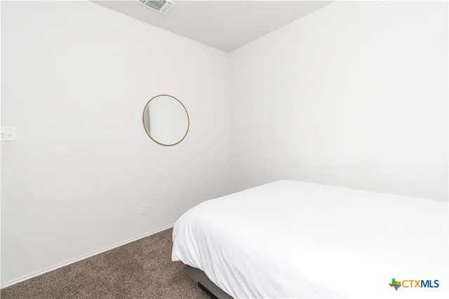 a bedroom with a bed and a wall painting