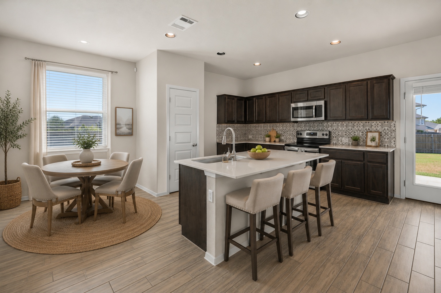 215 Lake Placid Run Elgin, TX 78621 - Photo 2 of 33 Rich dark cabinetry and patterned tile details define this open-concept kitchen and dining area.