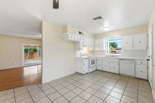 a kitchen with a sink window and cabinets