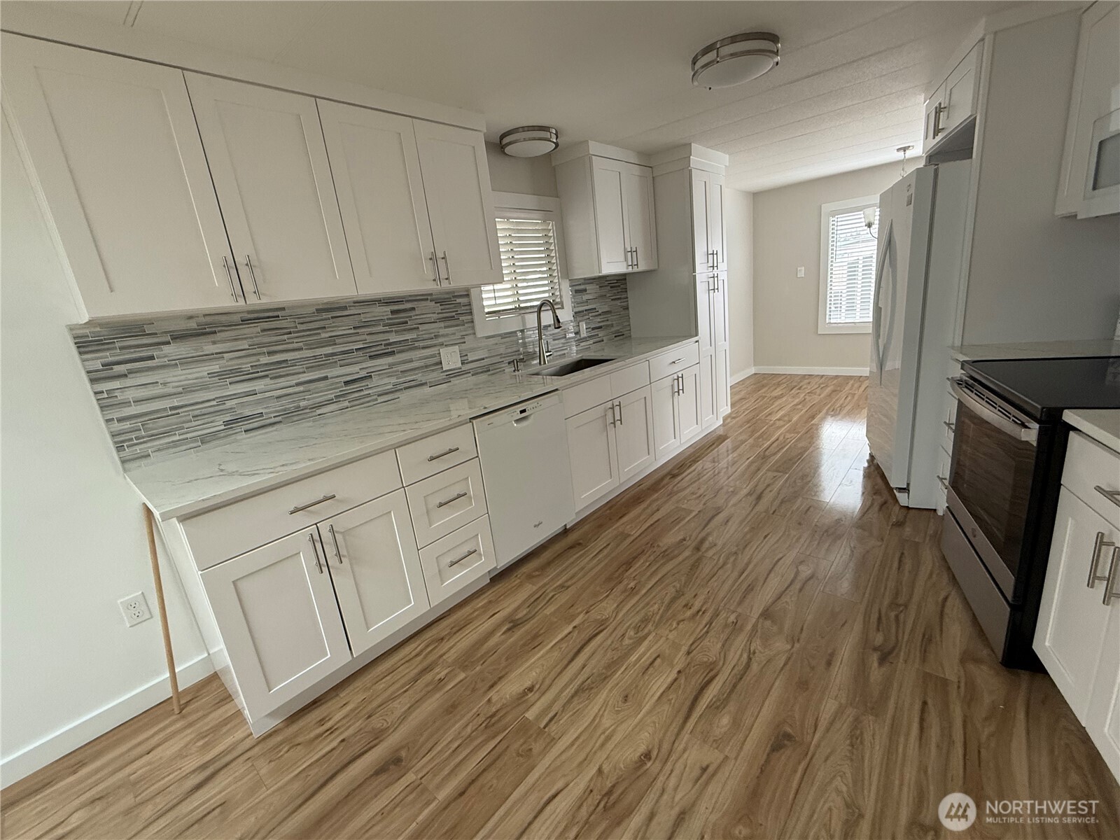 1415 84th Street Southeast, Unit 83 Everett, WA 98208 - Photo 13 of 34 a kitchen with granite countertop white cabinets and wooden floor