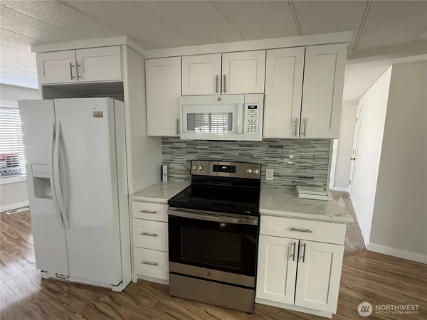 a kitchen with white cabinets and stainless steel appliances