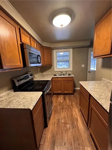 a kitchen with stainless steel appliances granite countertop a stove a sink and a microwave