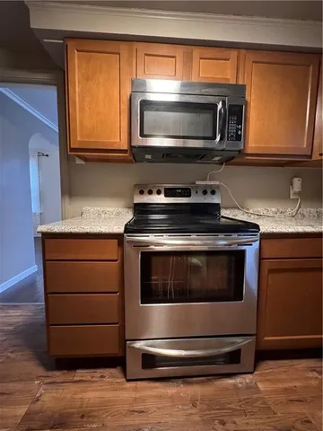 a kitchen with granite countertop a stove microwave and sink