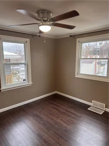 a view of wooden floor and windows in a room