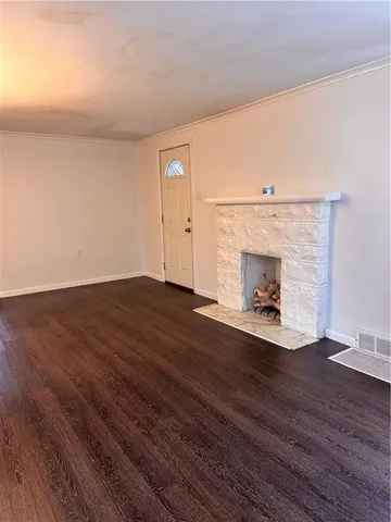 a view of empty room with wooden floor and fireplace