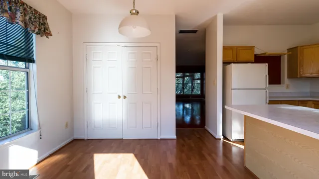 a kitchen with a refrigerator a stove a sink a counter top space and cabinets