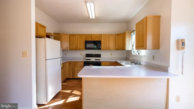 a kitchen with stainless steel appliances a stove a sink a microwave and wooden cabinets