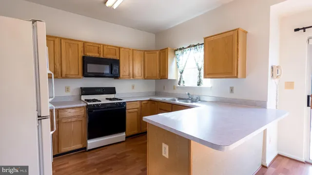 a kitchen with a sink a stove cabinets and a window